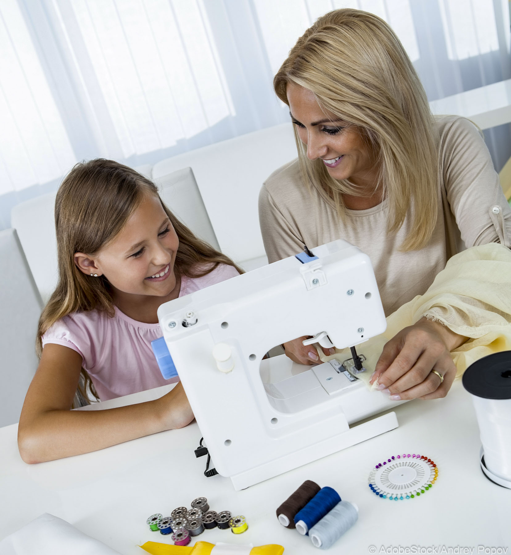 Portrait Of A Beautiful Young Girl Sewing With Her Mother At Home